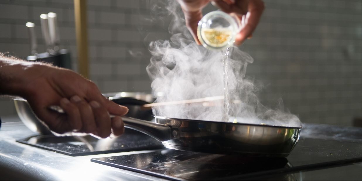 Beim Braten in der Pfanne entsteht Rauch in der Küche.