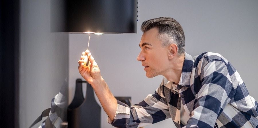 Man changes bulbs for winter in kitchen