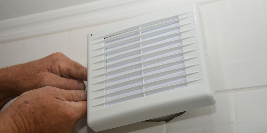 Man installing a bathroom air exhaust fan