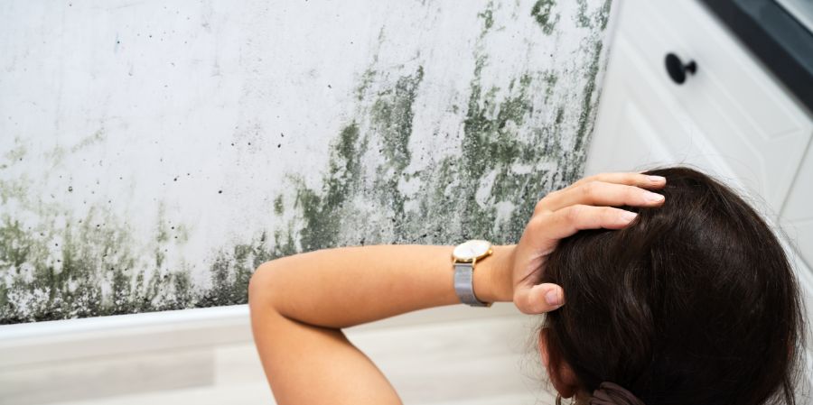 Girl distressed by mold on the wall